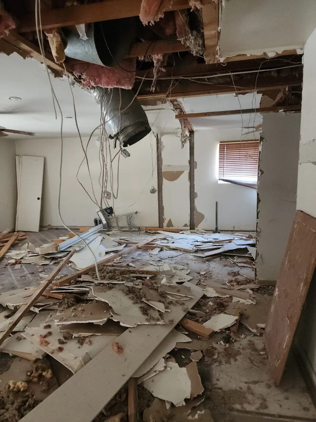 Interior demolition in progress with drywall and ceiling removed